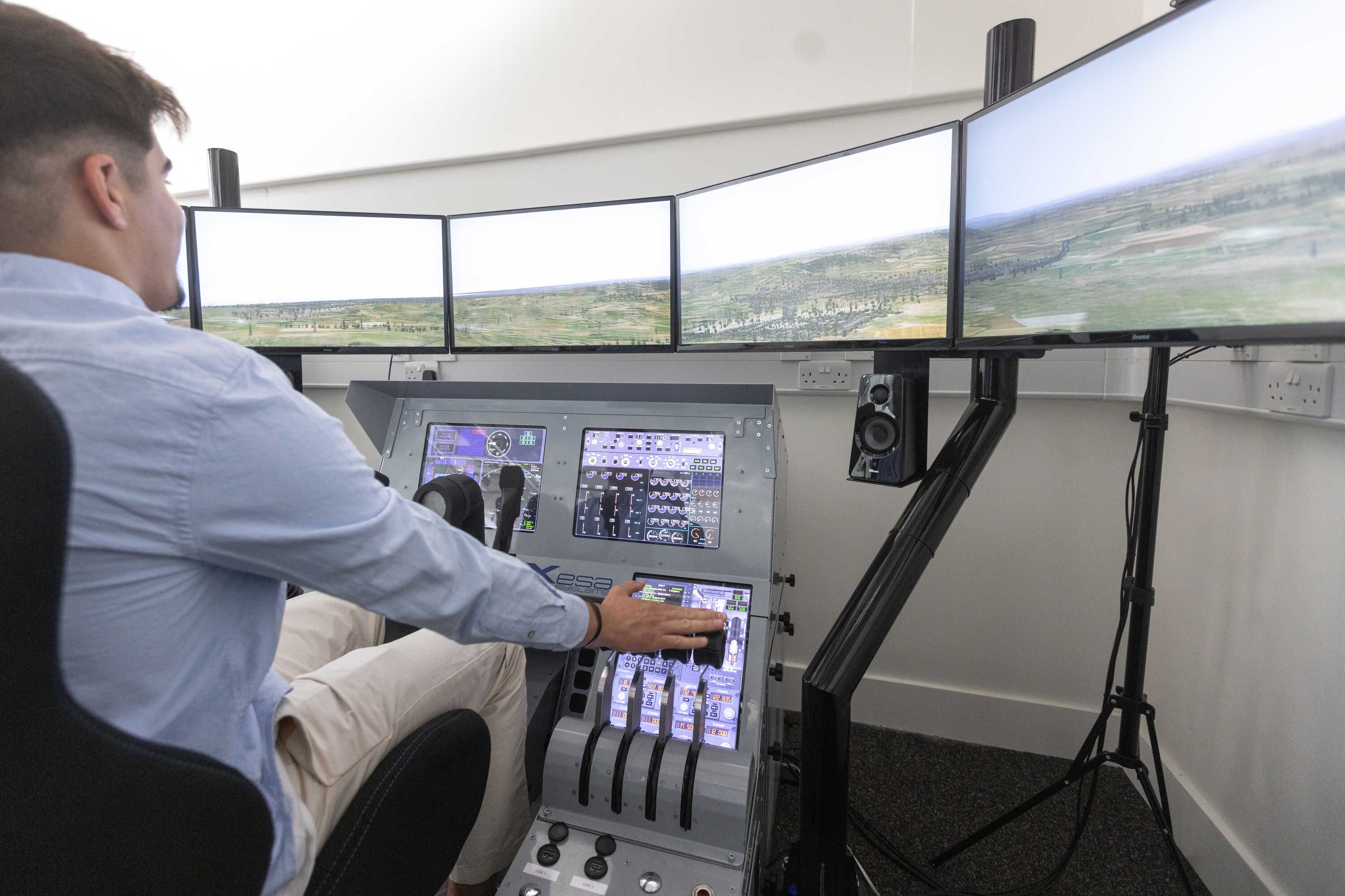A student using a flight simulator in aeronautics